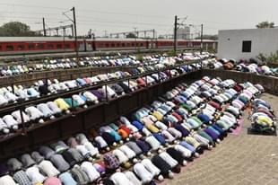 Devotees take part in the afternoon prayers  at the railway yard of the New Delhi Railway Station. (Sanchit Khanna/Hindustan Times via Getty Images)