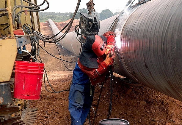 Engineers weld carbon steel pipes as part of a gas pipeline. (NOAH SEELAM/AFP/Getty Images)
