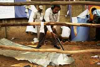 An explosives expert surveys the site of a low intensity blast outside Chinnaswamy stadium. (Getty Images)
