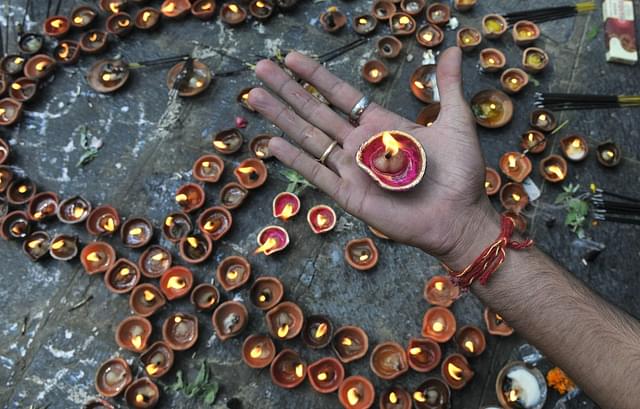 A Kashmiri Hindu devotee holds an oil lamps at the Kheer Bhawani Temple. (Waseem Andrabi/Hindustan Times via Getty Images)