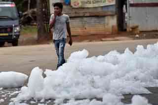 A youngster walks through flying froth from the polluted Bellandur Lake in Bengaluru. (Arijit Sen/Hindustan Times via GettyImages)&nbsp;