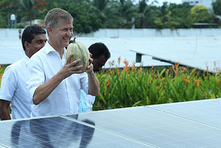 UN Global Chief of Environment and Executive Director of UNEP Erik Solheim poses to the media with a pumpkin grown at the solar power farm of Kochi airport.