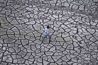 An Indian farmer walks on dry land in a drought-hit area (Sanjay Kanojia/AFP/Getty Images)