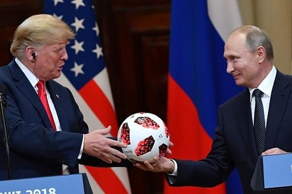Russia’s President Vladimir Putin (R) offers a ball of the 2018 football World Cup to US President Donald Trump during a joint press conference. (YURI KADOBNOV/AFP/Getty Images)