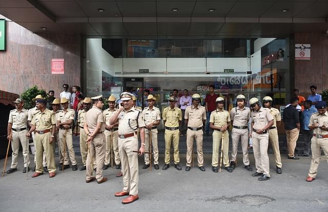 Police stand guard outside Lido Mall in Bengaluru as pro-Kannada activists threaten the release of Kaala movie, on 7 June 2018 (Arijit Sen/Hindustan Times via GettyImages)