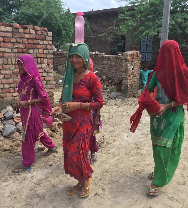 A woman with a water bottle on her head, which she carried for 2km. (Swarajya)