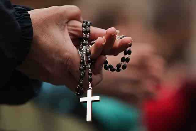 Woman holding a Christian cross. A Representative Image (Dan Kitwood/Getty Images)