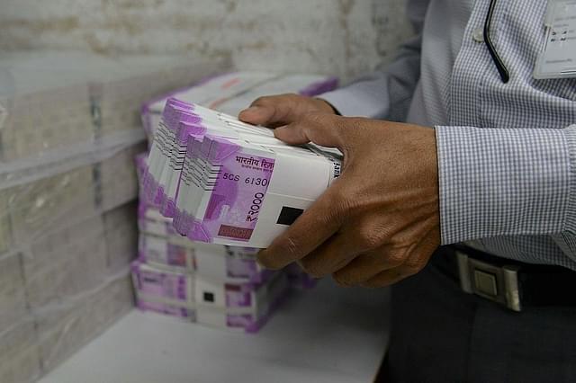 An Indian bank employee checks stacks of new 2,000 rupee notes (SAM PANTHAKY/AFP/Getty Images)