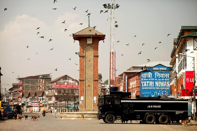 Pigeons fly at the deserted street during restrictions in Lal Chowk. (Abid Bhat/Hindustan Times via Getty Images)