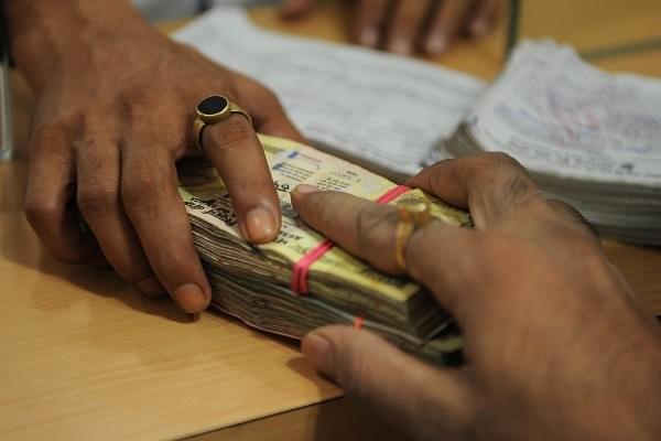A customer deposits cash at a bank. Image: INDRANIL MUKHERJEE/AFP/Getty Images