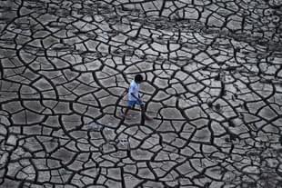 An Indian farmer walks on dry land in a drought-hit area. (Sanjay Kanojia/AFP/Getty Images)