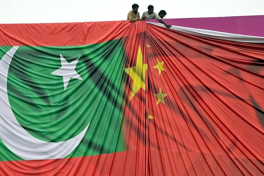 Workers set up a billboard welcoming President Xi Jinping to Pakistan ahead of his visit in 2015.&nbsp;
