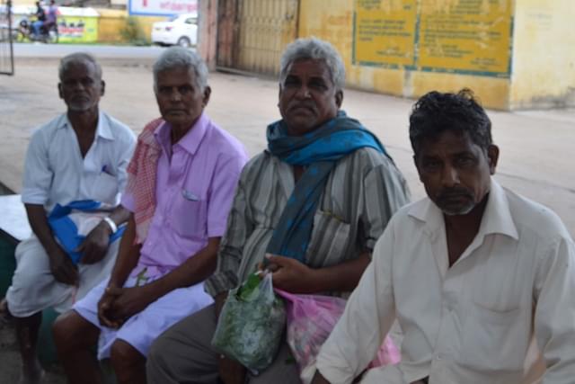 Chandrasekar, second from right, waits with his fellow farmers for his payment at the Vellore regulated market.