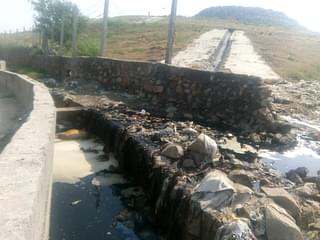 Liquid waste from the landfill flowing into the roadside drain