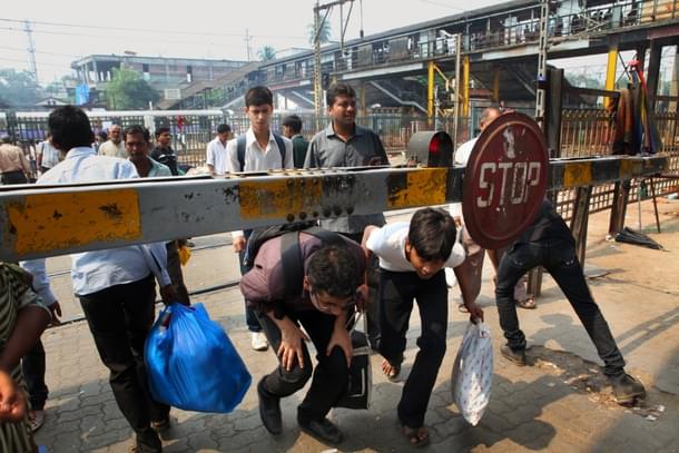 The Level Crossing Gate has been closed since long but people still cross tracks at Kandivali station on Tuesday. (Sattish Bate/Hindustan Times via Getty Images) 