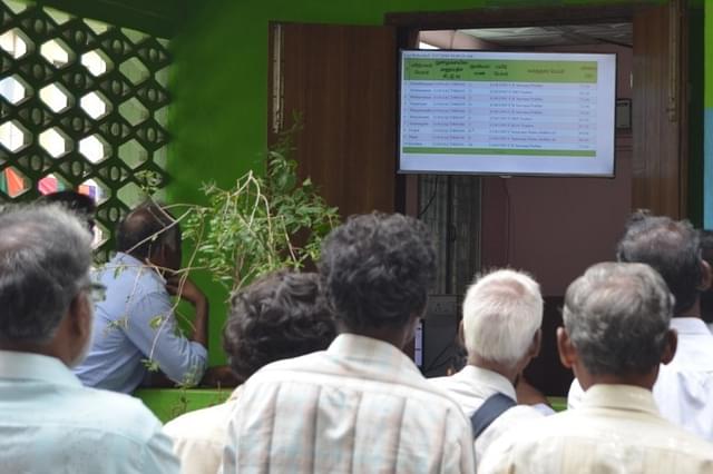 Farmers and traders look at details of successful bids through e-trading at the Vellore regulated market.