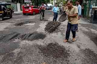 Municipal Corporation workers repairing potholes in Mumbai (Satish Bate/Hindustan Times via Getty Images)
