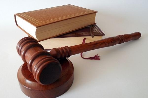 Representative image of a gavel and law books.