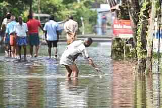 Residents wade through flood water  in the outskirts of Alappuzha, India. (Raj K Raj/Hindustan Times via Getty Images)
