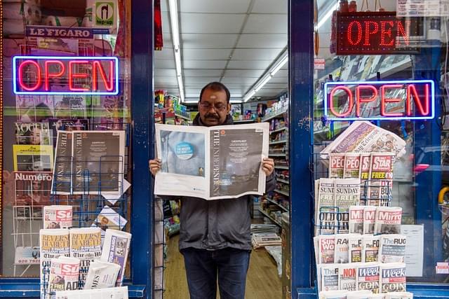 A newsagent reads the last ever print edition of The Independent On Sunday outside his shop  in London. (Chris Ratcliffe/Getty Images)&nbsp;