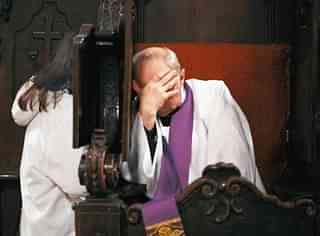 A Catholic priest hears a confession. (Oleg Nikishin/Newsmakers)