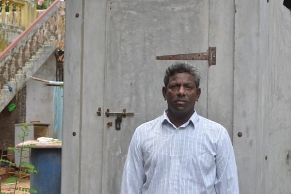 Ramamurthy of Alankuppam village, in front of the toilet built through pre-fabrication method.