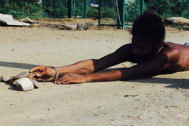 The route to devotion : A ‘sadhu’ moving stones to a spiritual milestone in ‘parikrama’. (Sumati Mehrishi/Swarajya)