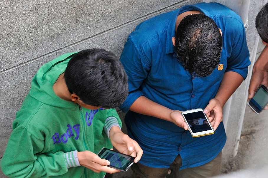 Boys surf the internet through their phones in India. (Waseem Andrabi/Hindustan Times via Getty Images)
