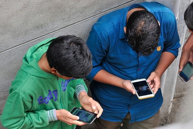 Boys surf the internet through their phones in India. (Waseem Andrabi/Hindustan Times via Getty Images)