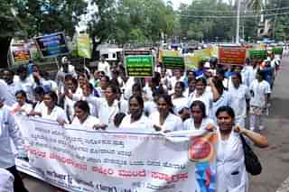Karnataka health department contract workers take out a rally demanding regularisation of their jobs.