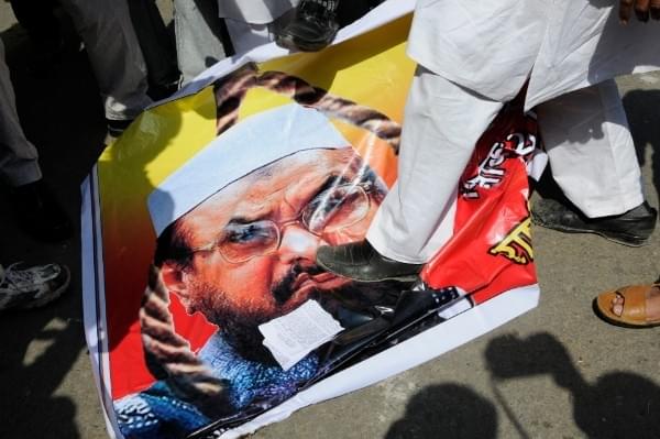 Protesters step on a poster featuring Lashkar-e-Taiba’s Chief Hafiz Saeed during an agitation in New Delhi (Photo by Pankaj Nangia/India Today Group/Getty Images)