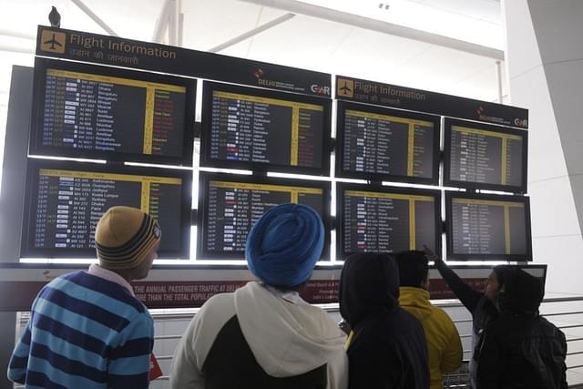 The passengers looking at flight schedule display at T-3 terminal Indira Gandhi International Airport. (Sushil Kumar/Hindustan Times via GettyImages)