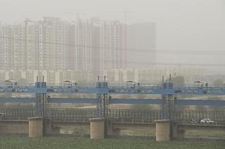 Vehicles cross a barrage on Hindon River as dust covers the skyline in Ghaziabad. (Prakash Singh/AFP/Getty Images)
