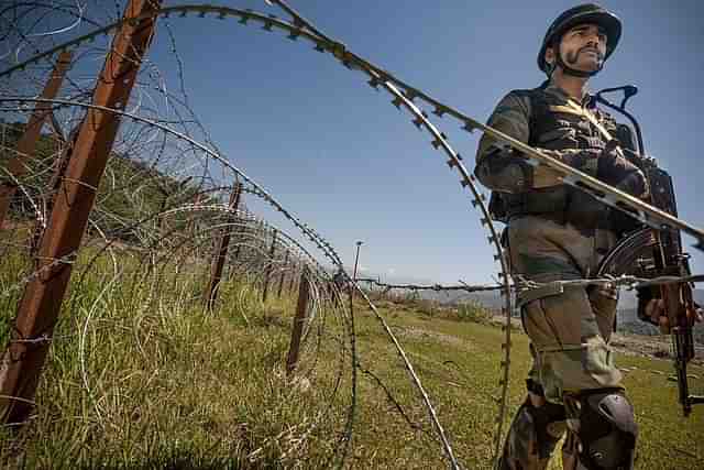 An Indian Army soldier patrols on the fence near the India-Pakistan LOC. (Gurinder Osan/Hindustan Times via Getty Images)