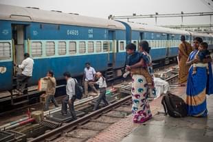 People rush to catch a train at a railway station (Photo by Brooke Herbert/Getty Images)