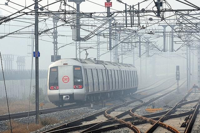 A metro train runs between Dwarka and Noida on a foggy morning in New Delhi. (Photo credits: PRAKASH SINGH/AFP/Getty Images)