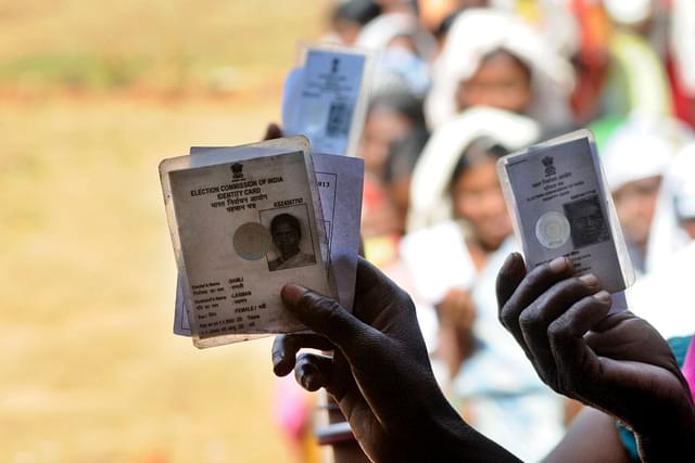 Voters showing voter ID card while standing in queue to cast their vote at a polling booth at a Chhattisgarh village. (Parwaz Khan/Hindustan Times via GettyImages)