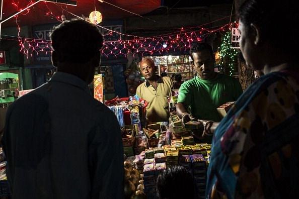 Customers buy fire crackers and fairy lights at a stall in the Anandapur area of Kolkata (Photo by Sanjit Das/Bloomberg via Getty Images)