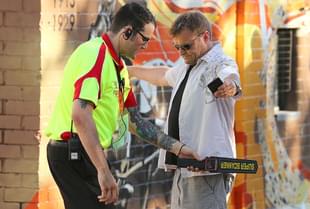 A security officer runs a metal detector over a man. (Paul Kane/Getty Images) 