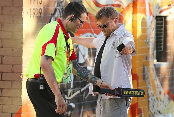 A security officer runs a metal detector over a man. (Paul Kane/Getty Images) 