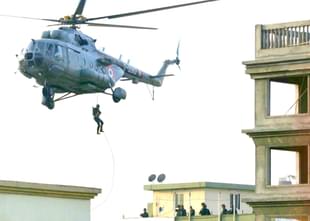 Military personnel abseiling from a helicopter. (Satish Bate/Hindustan Times via Getty Images) 