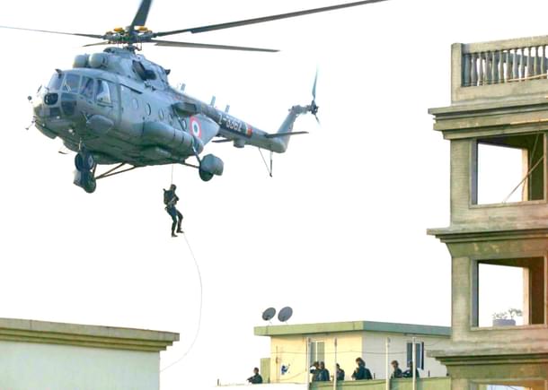 Military personnel abseiling from a helicopter. (Satish Bate/Hindustan Times via Getty Images) 