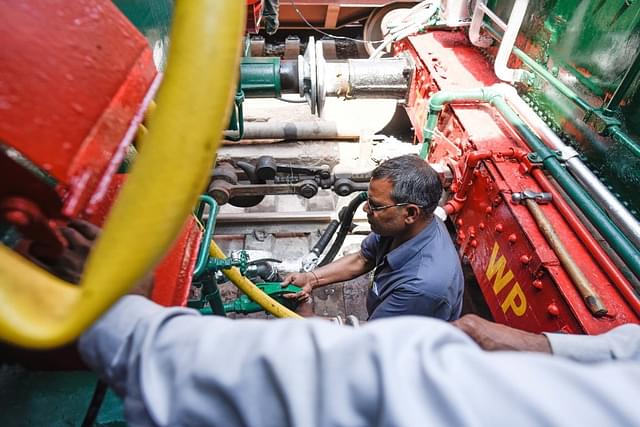 A railway worker works on the steam engine heritage train before its flag off  (Photo by Burhaan Kinu/Hindustan Times via Getty Images)
