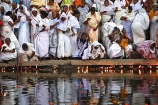Widows of Vrindavan lighting earthen lamps at the banks of Yamuna River as they begin their three-day Diwali celebrations in Vrindavan, India. (Ajay Aggarwal/Hindustan Times via Getty Images)