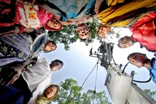 Villagers are standing around a poll eagerly waiting for the flow of electricity in village Garanayarchhara (Indranil Bhoumik/Mint via Getty Images) 