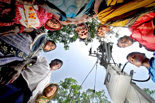 Villagers are standing around a poll eagerly waiting for the flow of electricity in village Garanayarchhara (Indranil Bhoumik/Mint via Getty Images)&nbsp;