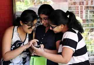 Students check exam results via smartphones. (Sushil Kumar/Hindustan Times via Getty Images)