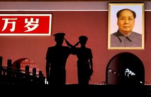 Chinese soldiers salute near Mao’s portrait in 2014 (Kevin Frayer/Getty Images)