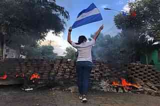 A woman carries the Nicaraguan flag during anti-government protests. (Pic by Voice of America via Wikipedia)
