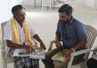 Ramachandran alias Somu, left, shows his documentation of decades of archaeological discoveries at Kodumanal to a visitor.&nbsp;